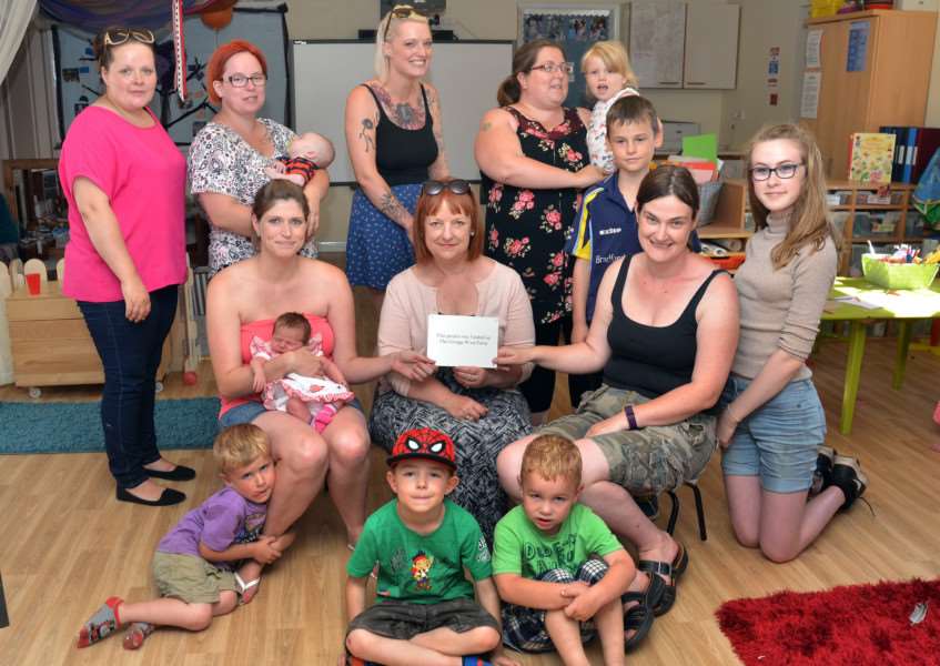 Kerry Bailey and Ella Cooper (middle left and right) with Karen Treacher of the Grange Wind Farm Comittee, parents and youngsters at the unveiling of a new floor at Cinder Ash Pre-School, Long Sutton. Photo by Tim Wilson.