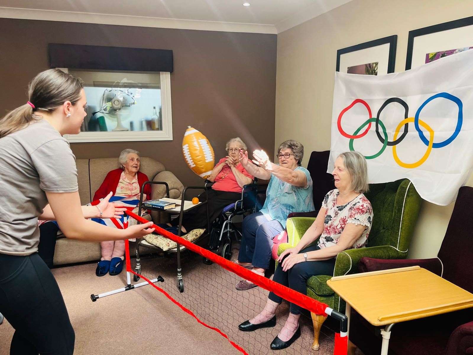 Residents playing volleyball with volunteer.
