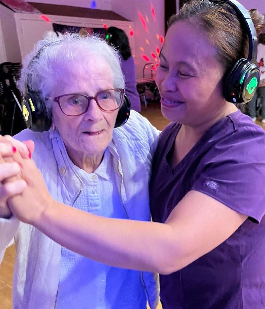 One of the residents enjoys a dance with the help of a staff member