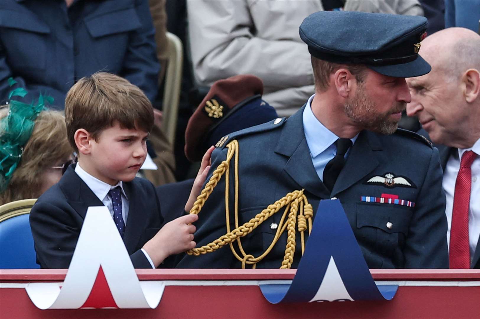 Louis hangs onto his father’s gold aiguillettes, the braided loops hanging from his RAF No.1 uniform. Toby Melville/PA