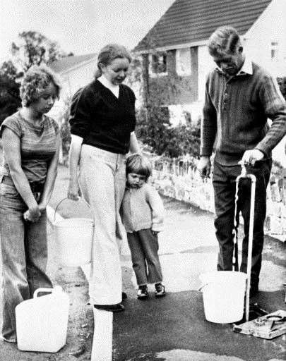 Residents of Peryn Road, Tavistock, Devon fill buckets from a water standpipe in the street during water rationing in September '76. Photo credit: PA/PA Archive.